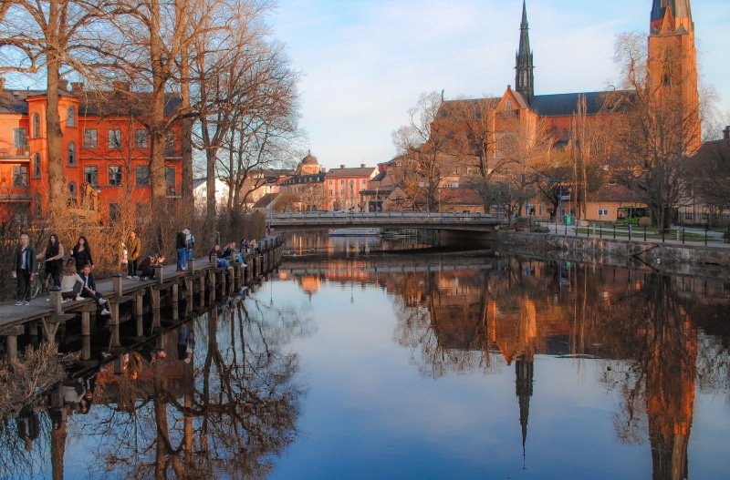 Uppsala Cathedral and river with people on a pier