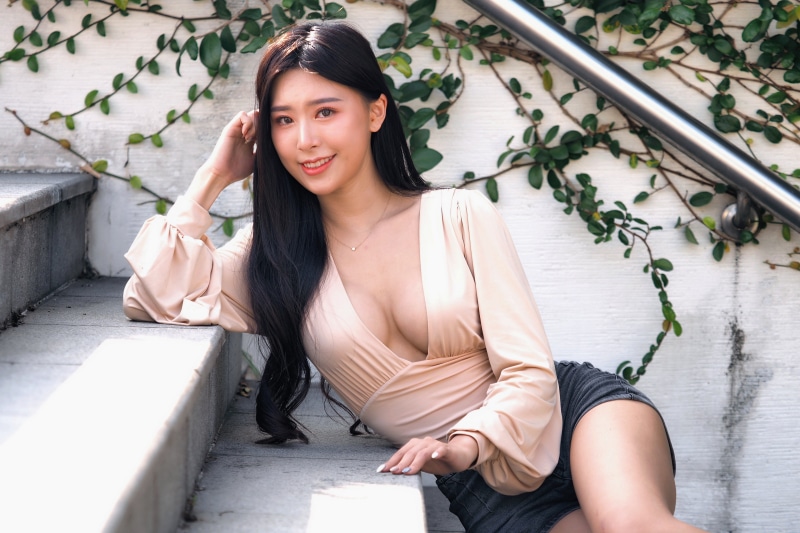 Asian woman in a low-cut blouse on stairs