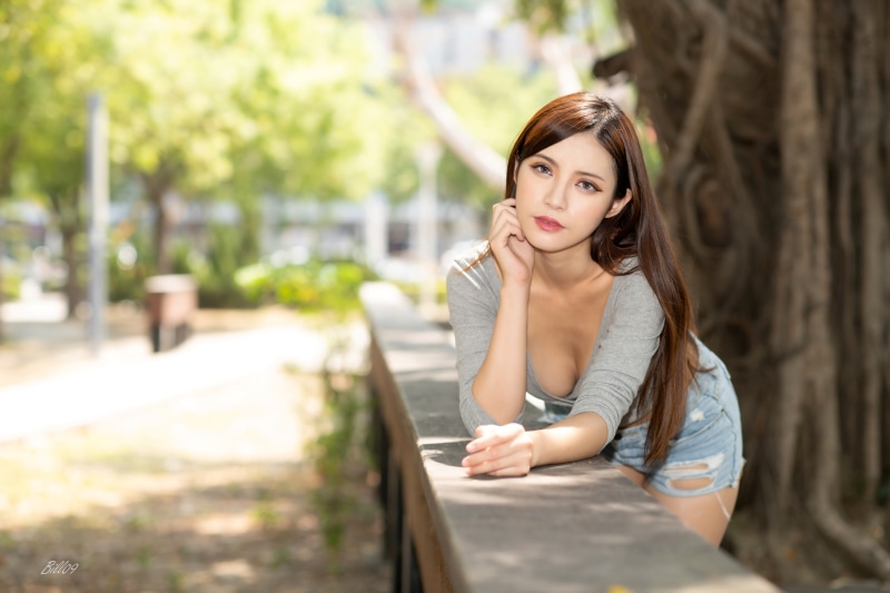 Asian woman with brown hair posing outdoors