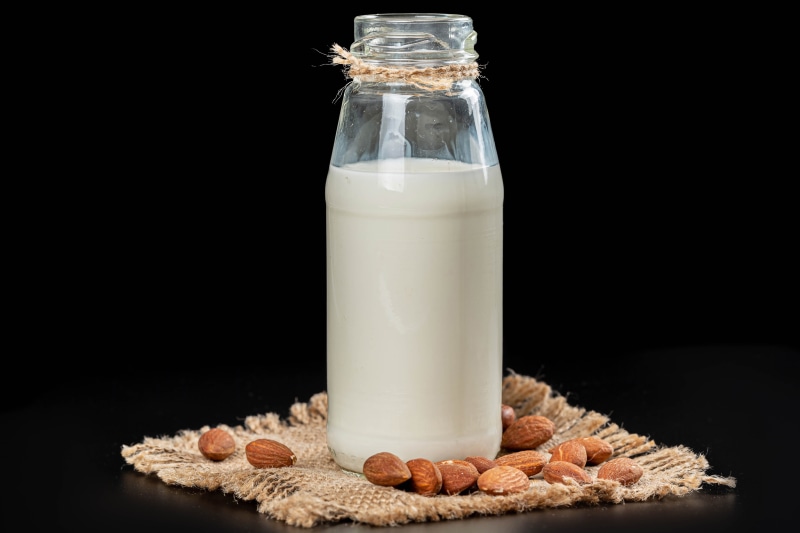 Almond milk in a bottle with almonds
