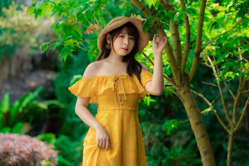 Asian woman in yellow dress and hat