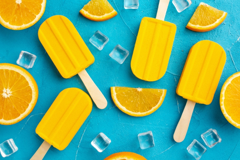 Orange popsicles with orange slices and ice cubes
