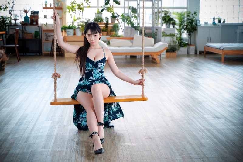 Brunette girl in dress on swing