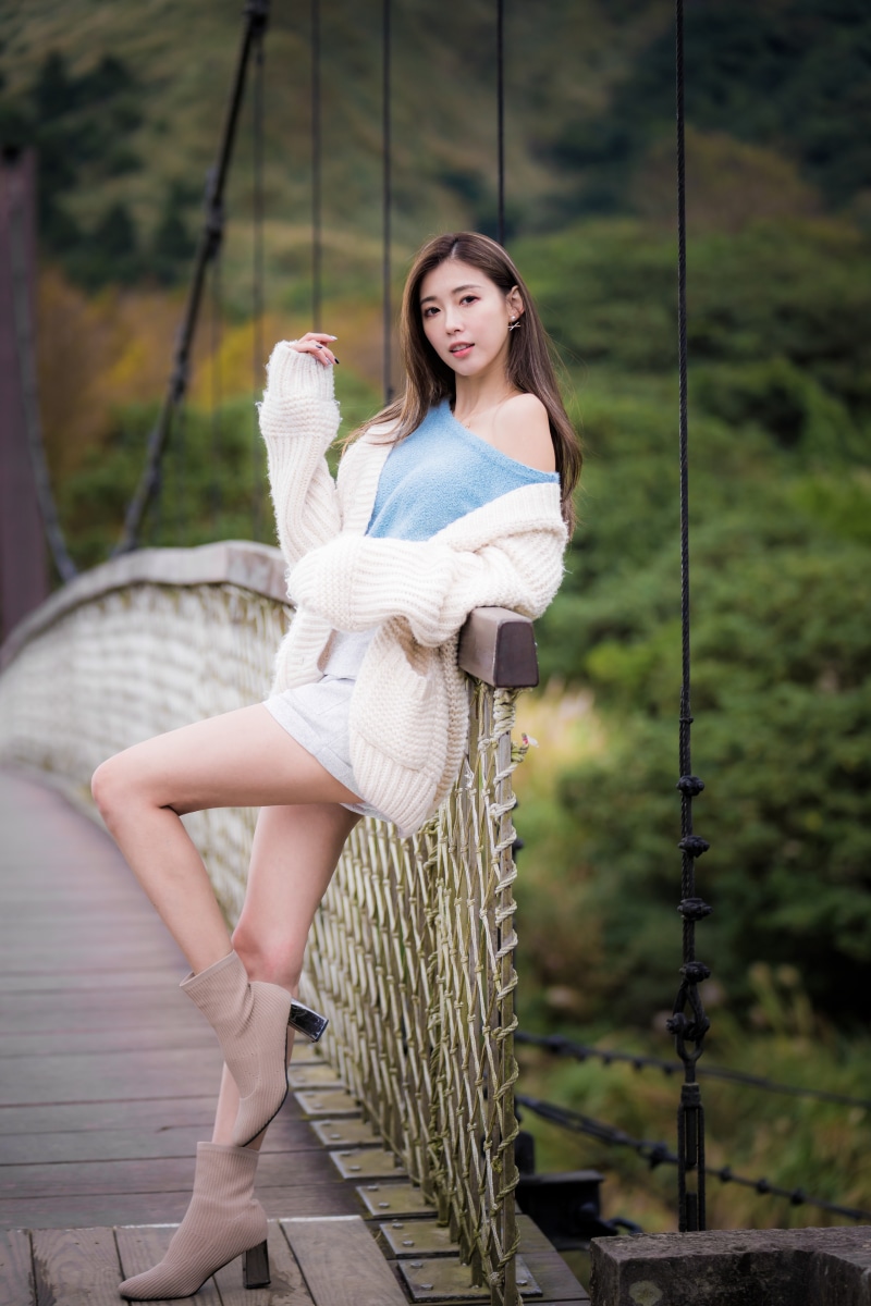 Asian woman posing on a suspension bridge