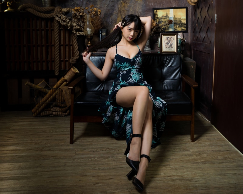 Brunette girl in a dress sitting on a sofa
