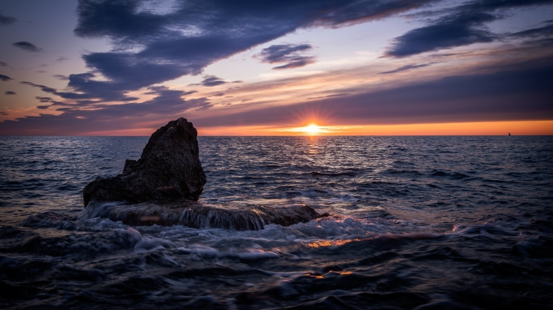 Sunset over the sea with a rock formation in Istria, Croatia