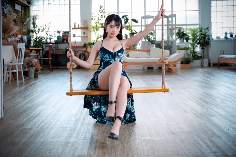 Asian woman in dress on swing