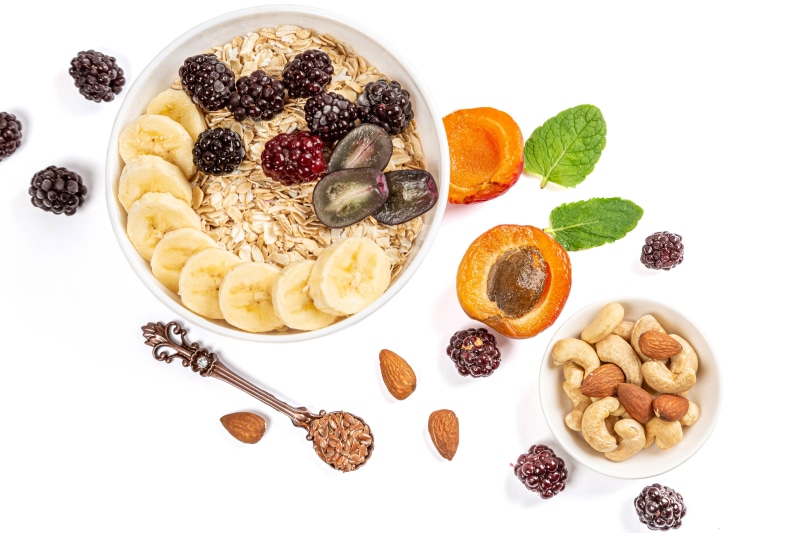 Oatmeal with Bananas, Blackberries, Apricots, Nuts, and Spoon