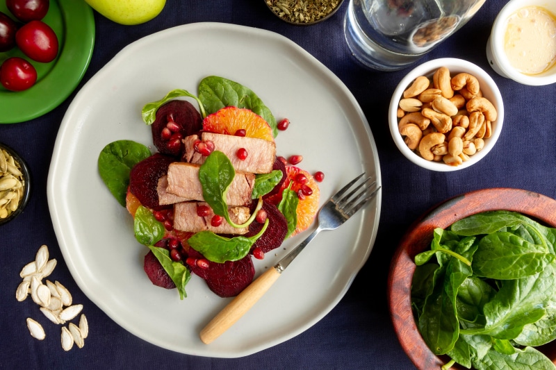Salad with meat, beets, and oranges on a plate