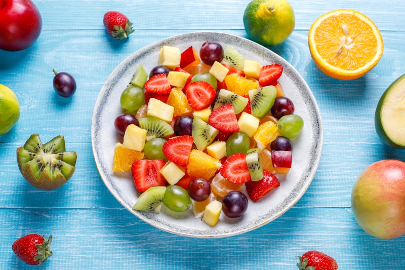 Fruit salad with strawberries, kiwi, grapes, and orange on a plate