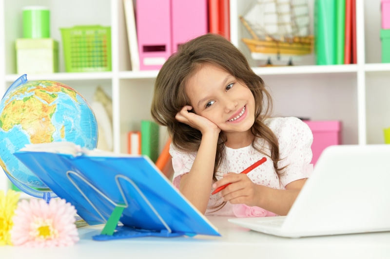 Little girl with laptop and globe