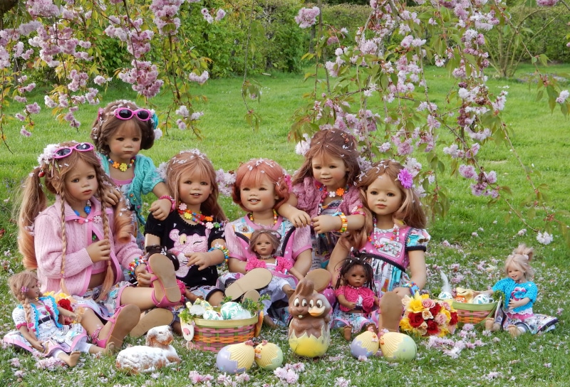 Dolls celebrating Easter in a park with flowering trees