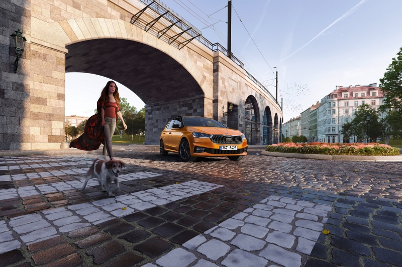 Orange Skoda Fabia with woman and dog near bridge