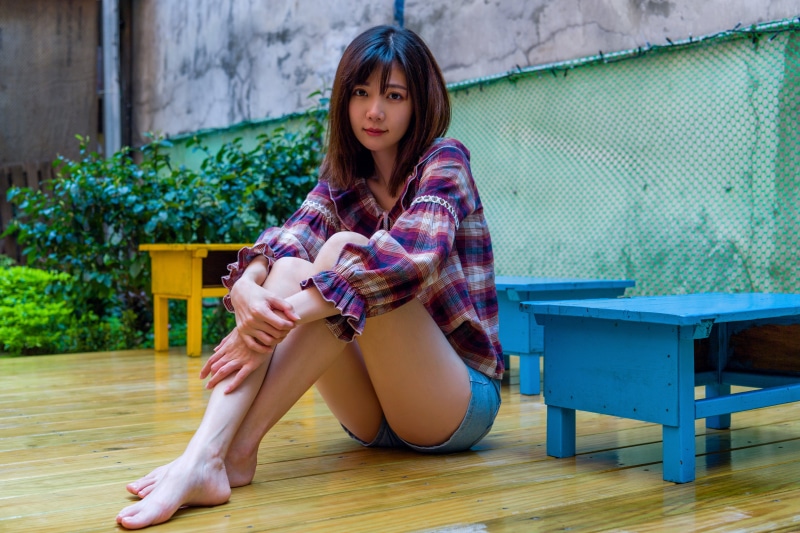 Asian woman sitting on a wooden deck