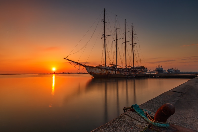 Abandoned ship at sunrise in marina