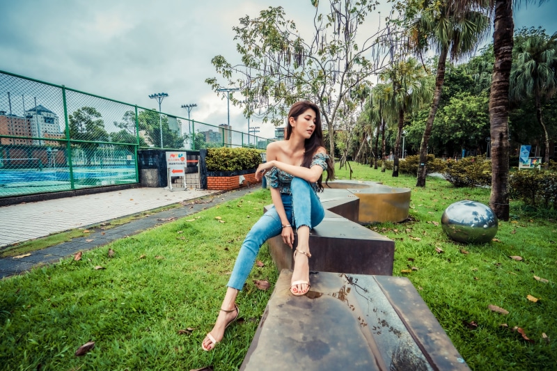 Asian woman sitting on a bench in a park