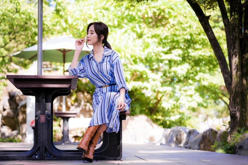 Asian woman sitting at a table outdoors
