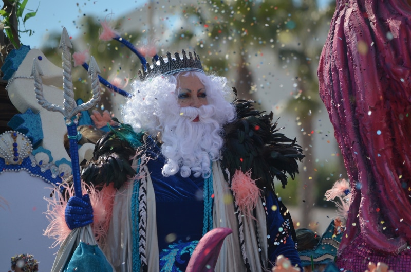 Man dressed as Neptune with a trident and crown