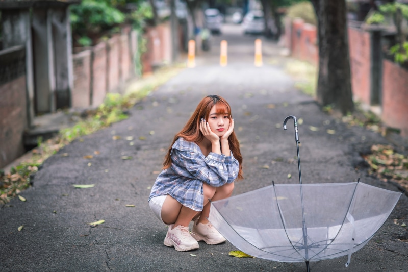Asian girl with umbrella on a street