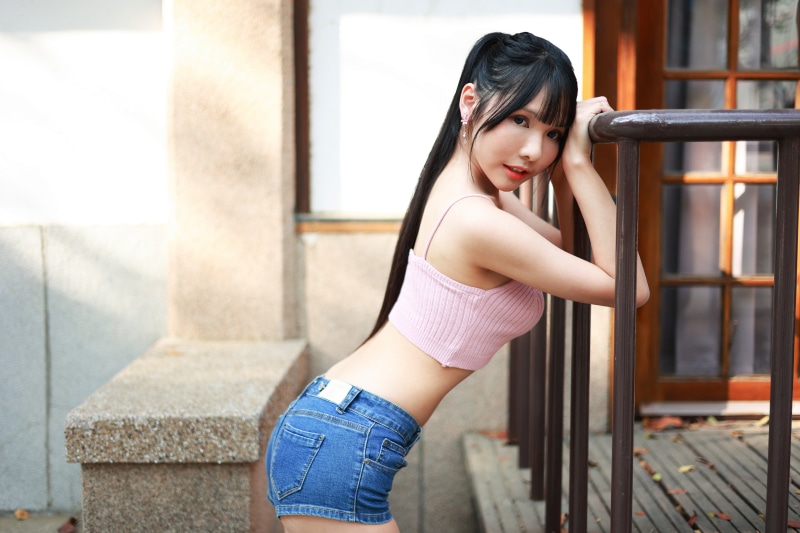 Asian girl in shorts and singlet posing