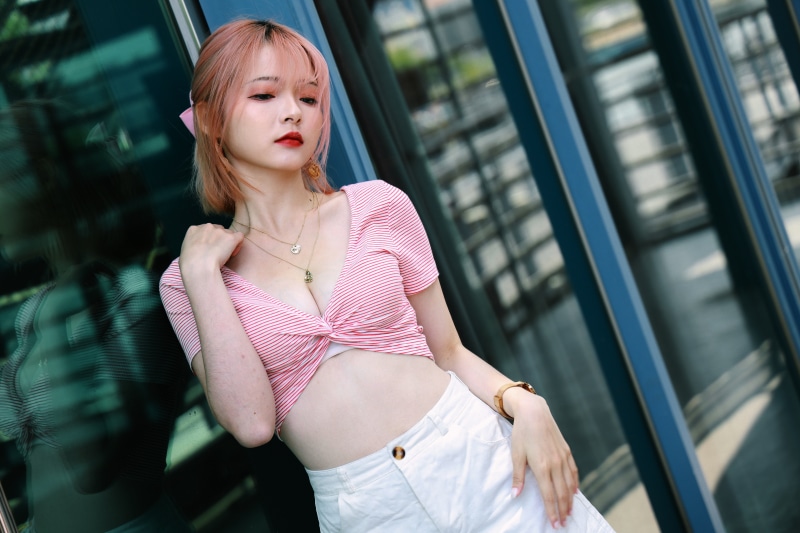 Asian woman in pink striped top and white shorts