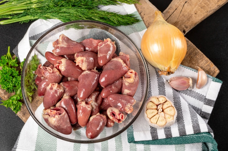 Raw chicken hearts with onion and garlic