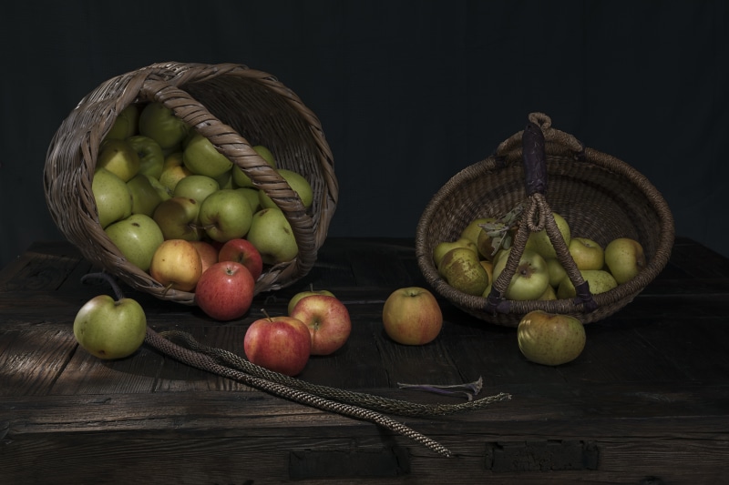 Apples in wicker baskets on wood planks