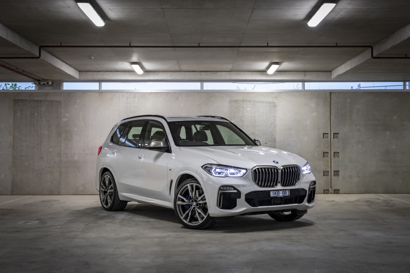 White BMW X5 M50d parked in a concrete garage