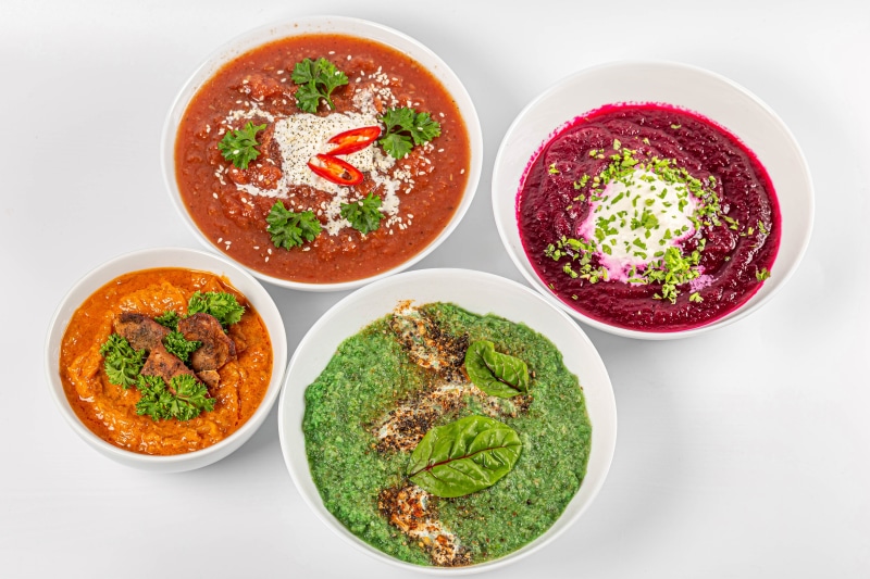 Four bowls of soup on a white background