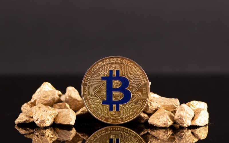Bitcoin coin surrounded by gold nuggets