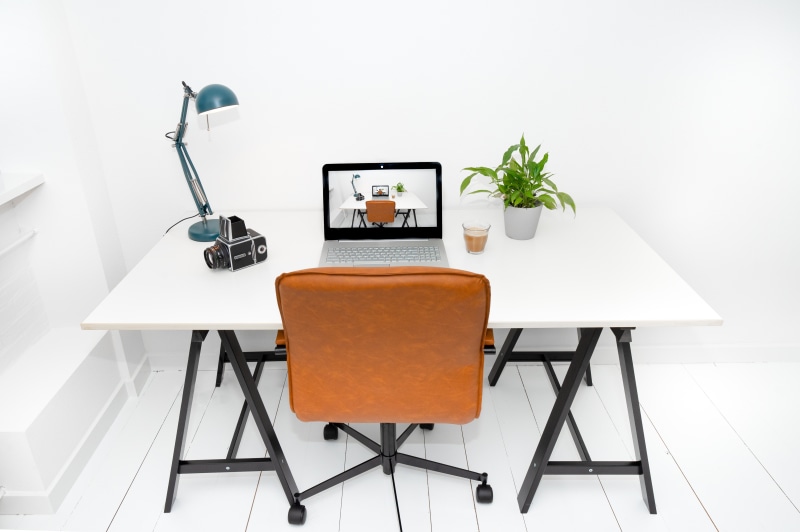 Desk with Laptop, Camera, Lamp, and Chair