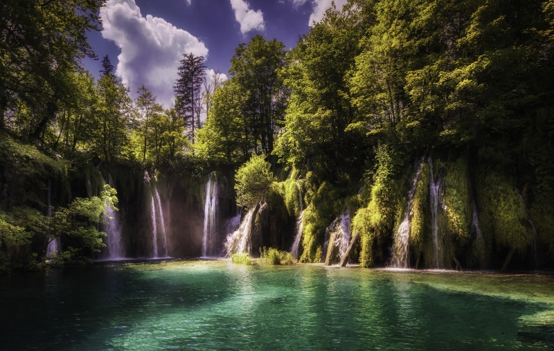Waterfalls cascading into a turquoise lake in Plitvice Lakes National Park, Croatia