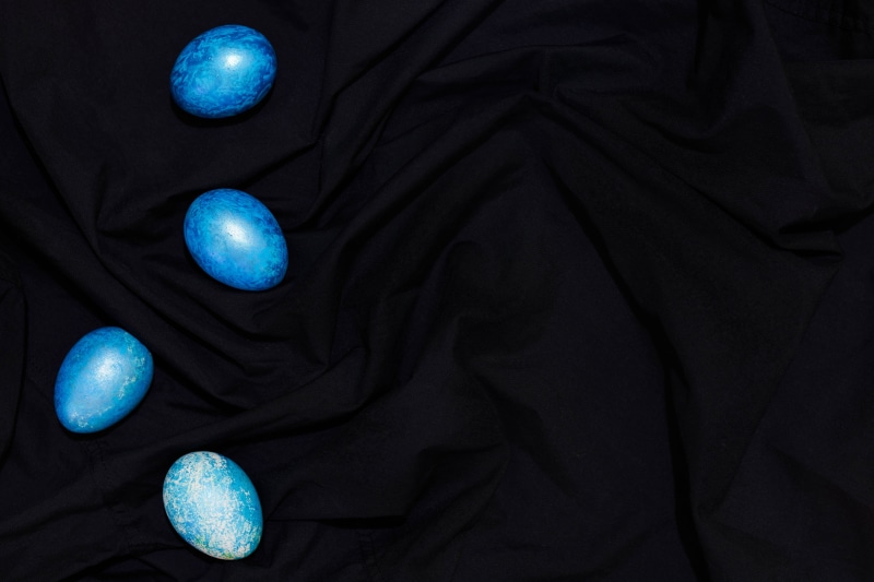 Four blue Easter eggs on black cloth
