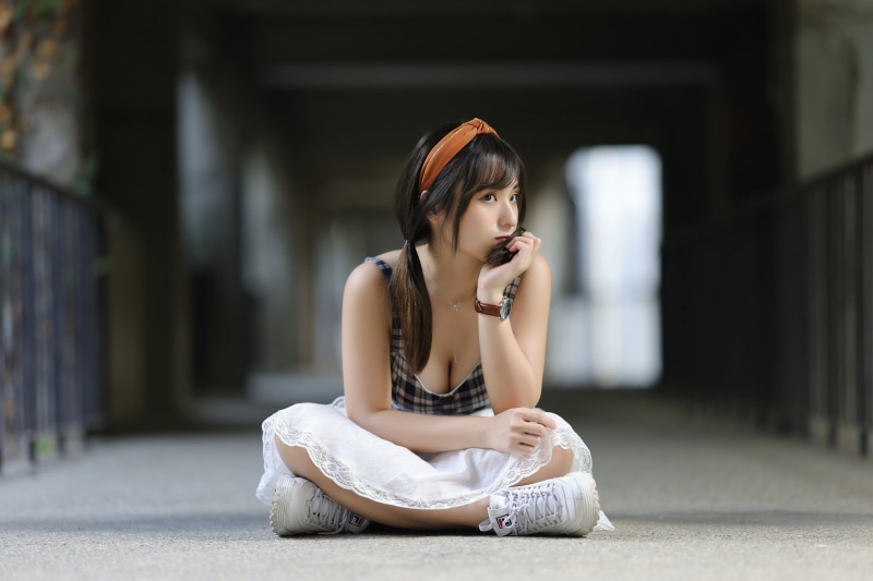 Asian woman sitting in a hallway
