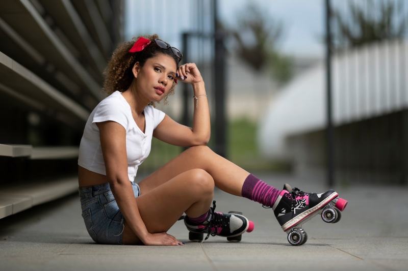 Woman with roller skates sitting on the ground