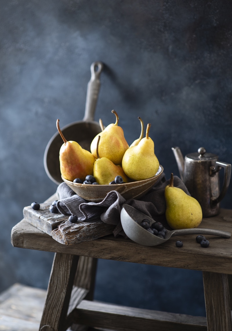 Still life of pears and blueberries on a wooden stool