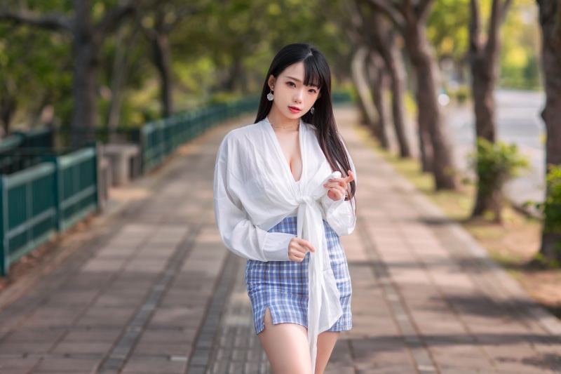 Asian woman in white blouse and plaid skirt