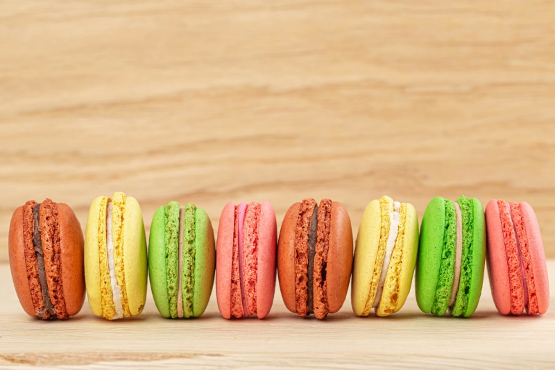 Row of colorful macarons on a wooden surface