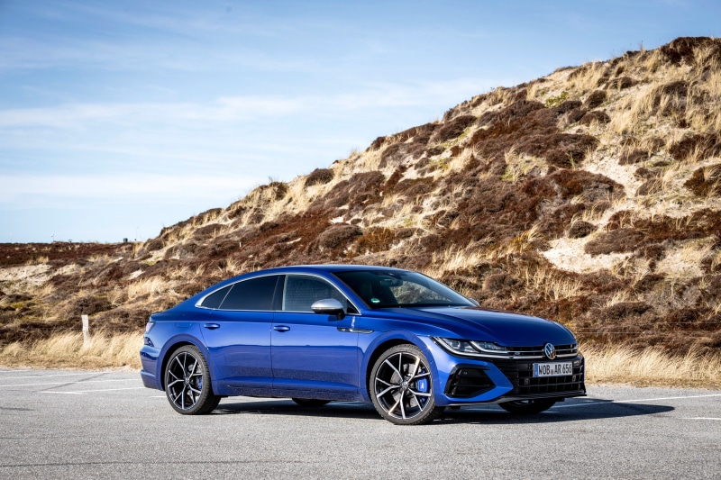 Blue Volkswagen Arteon R parked near a sandy hill