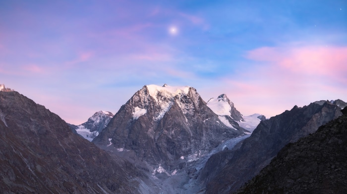 Snow-capped mountains under a colorful sky