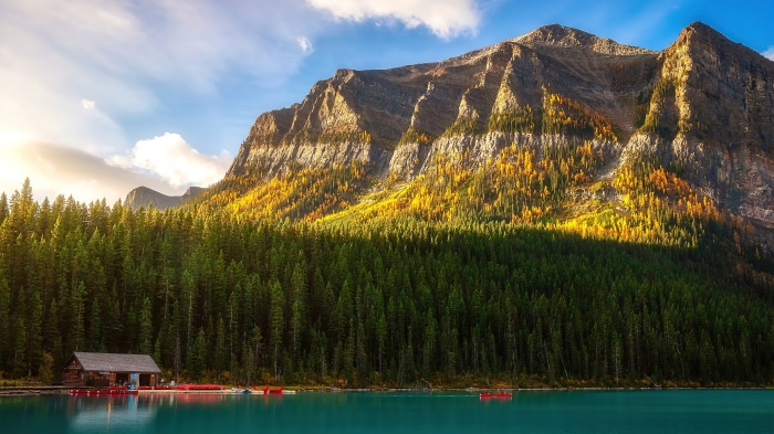 Cabin by a lake with forest and mountain scenery 4K