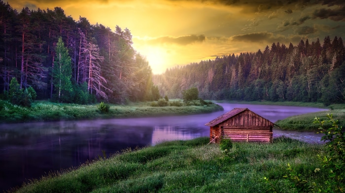 Cabin by the river in forest at sunset 4K