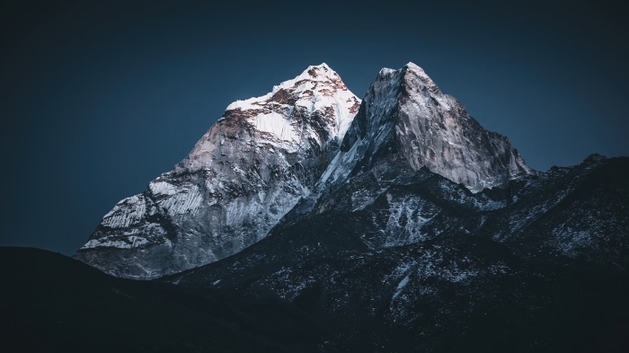Snowy mountain peaks against a dark blue sky, 4K