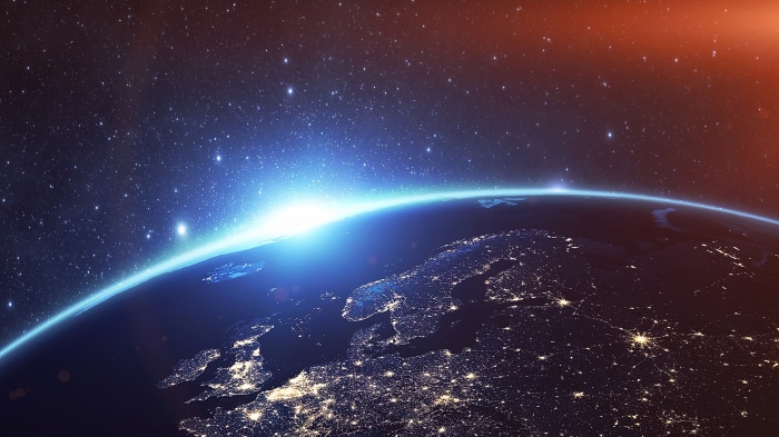 Earth from space with sunrise and city lights