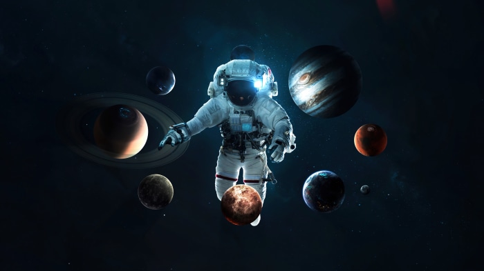 Astronaut floating among planets in space, 4K
