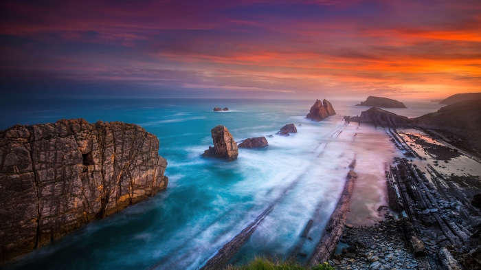 Rocky beach and coast with waves at sunset, Playa de Portio, Spain, 4K