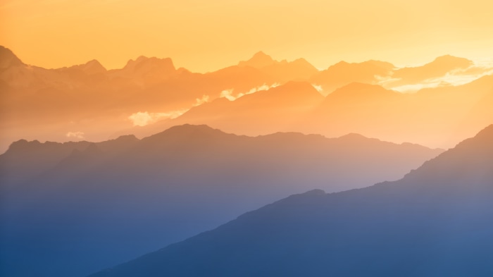 Mountain range at sunset with orange sky