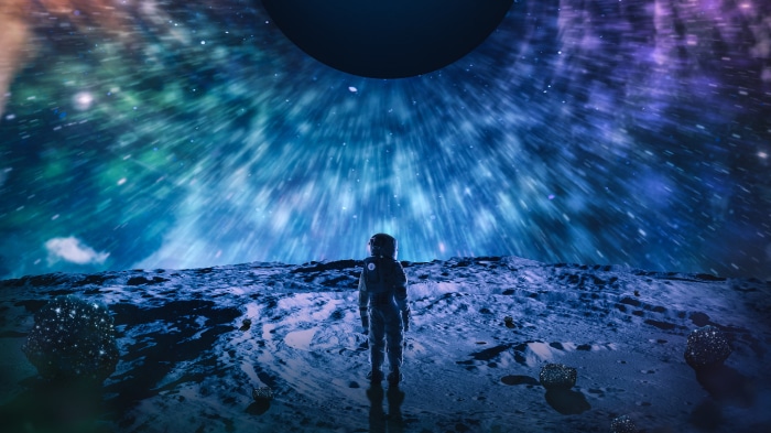 Astronaut on a planet looking at a colorful nebula
