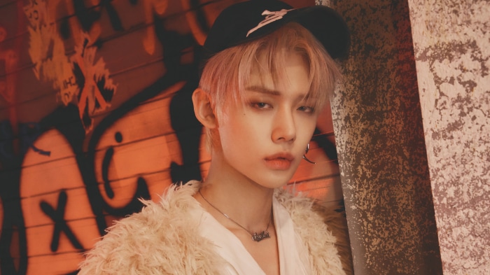 Yeonjun from TXT wearing a cap and fur coat
