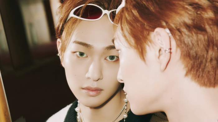 Onew looking into a mirror
